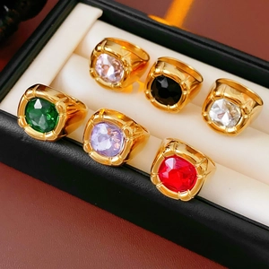 Dettaglio di sei anelli vintage dorati con zirconi colorati in una scatola portagioie nera