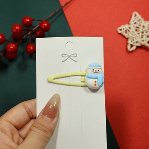 Detailed view of a yellow hair clip featuring a cute snowman resin charm for Christmas