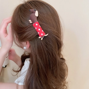 Close-up of a cute dachshund fabric hair clip with red polka dots worn by a model
