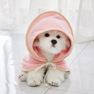 Detailed plush texture of pink hooded pet bathrobe on small dog with white tie bow