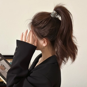 Minimalist silver metal hair claw clip with multi-coil design shown on model's ponytail