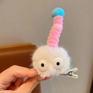 Gros plan d'une pince à cheveux chenille en peluche avec yeux blancs et antennes roses