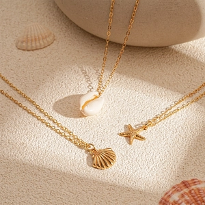 Three-piece beach style necklace set with starfish, seashell, and golden fan pendants