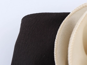 Dettaglio delle imbottiture per reggiseno nere e beige con cuciture rinforzate e tessuto