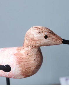 Macro detail of hand-painted wood grain texture on a Nordic style bird ornament
