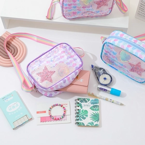 Glitter girl crossbody bag with rainbow strap and star heart patches on white desk