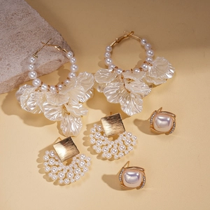 Detailed macro view of gold plated earrings featuring pearls and acrylic flower petals