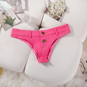 Détail du short en jean rose vif taille basse avec double bouton sur fond en velours