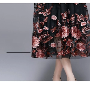 Detailed view of intricate vintage floral embroidery on black tulle midi skirt hemline