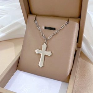 Close-up of silver titanium steel cross pendant necklace in an elegant jewelry box