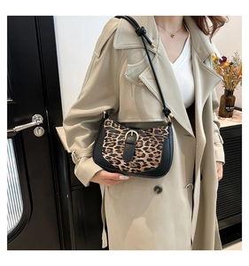 Detail of leopard print shoulder bag with gold horseshoe buckle and knotted strap design