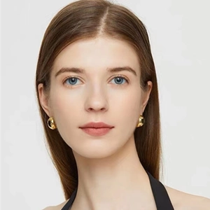 Detail of chubby gold crescent earrings on model showing size and high-shine metallic finish