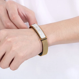 Detail showing a gold mesh band bracelet with a sparkling rhinestone plate on wrist
