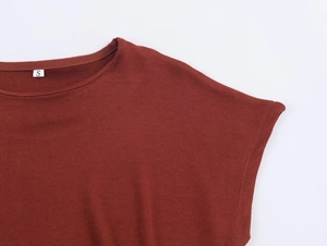 Gros plan du haut en maille rouge rouille montrant la texture côtelée et l'étiquette S