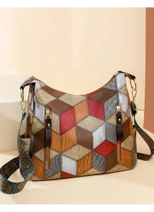 Detail view of the geometric multi-color handbag with dual zippers and patterned strap
