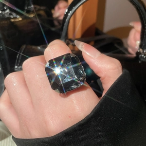 Detail of a large octagonal black gemstone ring with prong setting on a model hand