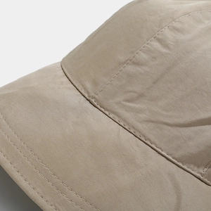 Macro detail of khaki baseball cap featuring precision double stitching on woven twill fabric