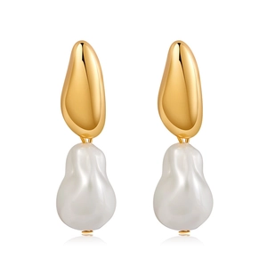 Detailed view of irregular gold earrings with white baroque pearls and metallic texture