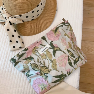 Elegant floral jacquard cosmetic bag with pink flowers on a soft white quilted background