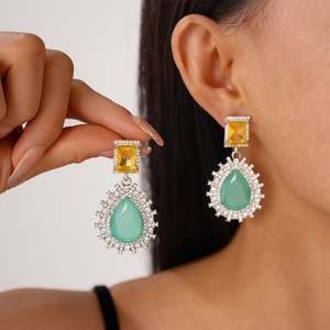 Detail of drop earrings with yellow square stone and mint green teardrop crystal