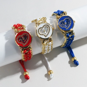 Three quartz watches with woven bracelets and rhinestone heart dials on white display