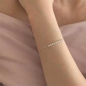 Detail of s925 sterling silver geometric bracelet with white zircons on a wrist