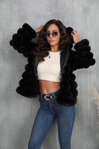 Detail of a plush black faux fur jacket texture with trendy cropped inner top and jeans