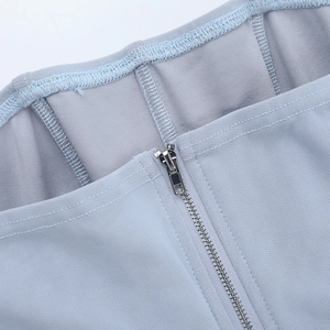 Vue macro du tissu en mesh et de la fermeture éclair métallique sur le haut corset bleu