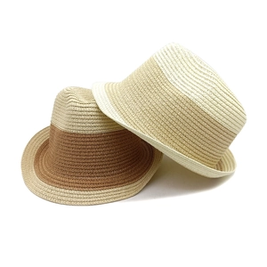 Detailed close-up showing two stylish color-blocked straw fedora hats for summer beach travel.