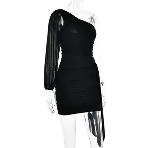 Détail de la mini robe noire à une épaule avec fronces et manche longue en mesh transparent