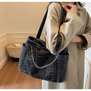 Side view of large black washed denim tote bag on model for casual slouchy look