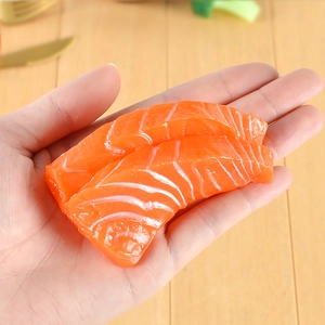 Modèle de sashimi de saumon réaliste en PVC avec rayures de gras tenu dans la main