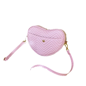 Pink heart-shaped crossbody bag with V-quilted stitching and gold metal hardware