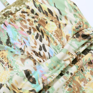 Detail of leopard print fabric featuring golden sequins trim on a beach maxi dress