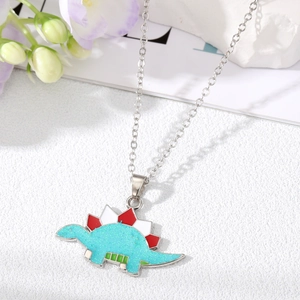 Macro shot of glitter teal stegosaurus dinosaur pendant with festive red Christmas hat