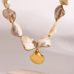 Macro detail of natural shell beads and golden shell pendant on ocean style necklace