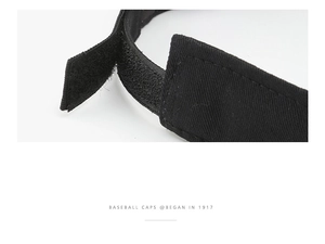 Detail of adjustable velcro strap and twill fabric on black baseball cap