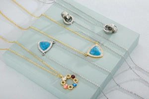 Detailansicht von Gold- und Silber-Edelstahlketten mit Kristall- und Türkis-Anhängern