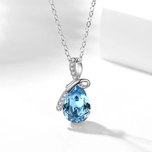 Detail of the elegant water blue teardrop crystal pendant on a silver-tone chain