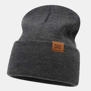 Close-up of dark grey ribbed beanie with a brown leather patch featuring DAD lettering