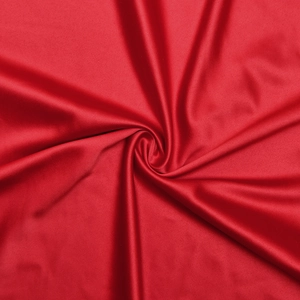 Gros plan sur la texture du tissu satiné rouge foncé avec des plis élégants