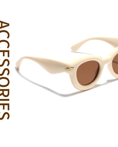 Detail view of cream cat-eye sunglasses with rice nail rivets at a 45-degree angle