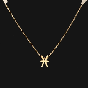 Macro shot of gold Pisces constellation pendant on delicate chain with black background