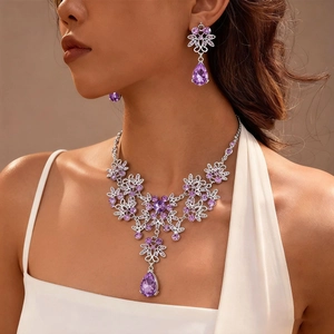 Detail of necklace set with purple teardrop crystals and silver floral vine design