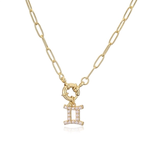 Detailed close-up of a gold Gemini pendant with white pearls on a paperclip chain