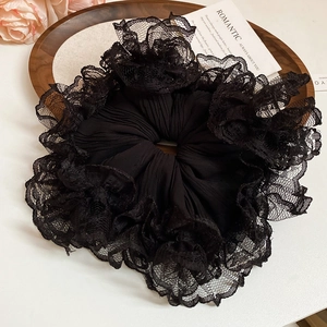 Détail de chouchou en dentelle noire avec bordure de cils et texture plissée