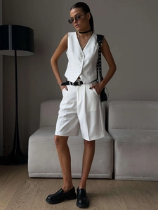 Close-up of white V-neck vest and tailored bermuda shorts set with sharp creased details