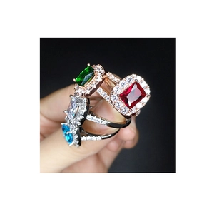 Adjustable silver and rose gold rings set with vibrant red, green, and blue gemstones