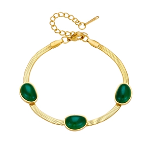 Dettaglio della collana a catena piatta dorata con pietre preziose verde smeraldo