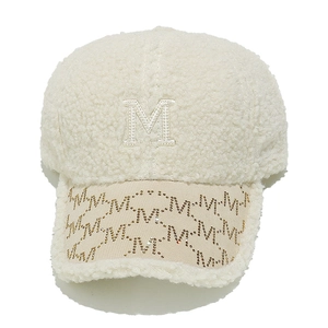 Detail of white sherpa baseball cap featuring embroidered M and gold rhinestone patterns